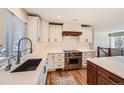 Bright kitchen featuring white cabinets, quartz countertops, stainless steel appliances, and modern fixtures at 6671 S Hill Way, Littleton, CO 80120