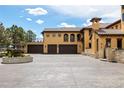 Mediterranean-style house with a fountain, large driveway, and multiple garage spaces at 8417 High Ridge Ct, Castle Pines, CO 80108