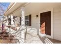 Close-up view of the front porch with a brown door and white pillars, showcasing the home's entrance at 1832 S Tamarac St, Denver, CO 80231