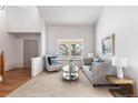 Bright living room with neutral decor, carpet flooring, and ample natural light from a large window at 1832 S Tamarac St, Denver, CO 80231