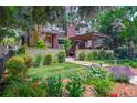 Exterior view of a landscaped yard with brick home, stone wall, manicured lawn, and flowering garden at 460 Garfield St, Denver, CO 80206