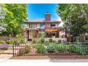 Beautiful brick home exterior with manicured landscaping, secure fencing, and a lovely stone accent wall at 460 Garfield St, Denver, CO 80206