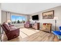 Sunlit living room with hardwood floors, large window and comfortable seating at 13225 W Jewell Cir, Lakewood, CO 80228