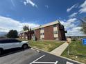 Brick apartment complex with ample parking, green space, and balconies at 3613 S Sheridan Blvd # 16, Denver, CO 80235