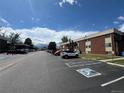 Asphalt parking lot with cars and a view of the brick apartment complex at 3613 S Sheridan Blvd # 16, Denver, CO 80235
