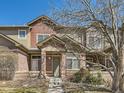 Inviting townhome entrance with brick accents, a neutral-toned door, and manicured garden at 6426 Silver Mesa Dr # C, Highlands Ranch, CO 80130