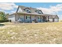 Two-story house with a front porch and three-car garage. Lovely landscaping and spacious yard at 402 S County Road 129, Bennett, CO 80102