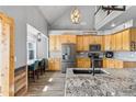 Bright eat-in kitchen with wooden cabinets, gray countertops, a large island, and modern stainless steel appliances at 402 S County Road 129, Bennett, CO 80102