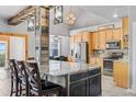 Kitchen island with granite countertop, wooden cabinets, and a rustic beam, providing an efficient workspace at 402 S County Road 129, Bennett, CO 80102