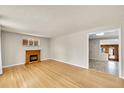 Bright living room with a decorative fireplace and hardwood floors, connecting to an adjoining room at 505 Empire St, Aurora, CO 80010