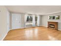 Sunlit living room featuring hardwood floors, fireplace, and large windows with sheer curtains at 505 Empire St, Aurora, CO 80010