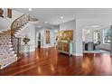 Elegant foyer featuring hardwood floors, a curved staircase, and stylish decor at 7050 S Polo Ridge Dr, Littleton, CO 80128