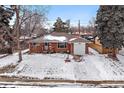 Quaint brick home showcasing an attached garage and a snow-covered front yard at 205 Coral Way, Broomfield, CO 80020