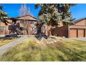 Exterior view of a home with mature trees and a well-maintained lawn and two-car garage at 9587 W 89Th Cir, Broomfield, CO 80021