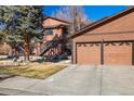Close-up exterior of a two-car garage featuring paneled doors on a sunny day at 9587 W 89Th Cir, Broomfield, CO 80021