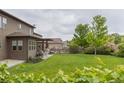 Spacious backyard with a lush lawn, a covered patio, and mature trees, perfect for outdoor living at 11880 W 38Th Pl, Wheat Ridge, CO 80033