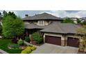 Elegant two-story home with a well-manicured front yard and a three-car garage in a beautiful neighborhood at 9470 S Silent Hills Dr, Lone Tree, CO 80124