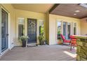 Inviting front porch with seating, decorative flower pots, and a welcoming wreath on the front door at 9470 S Silent Hills Dr, Lone Tree, CO 80124
