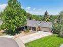 Aerial view of a charming residence with a well-manicured lawn, mature trees, and a spacious driveway at 11035 W 26Th Pl, Lakewood, CO 80215