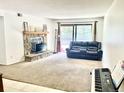 Spacious living room featuring a stone fireplace, plush carpeting, and sliding glass doors to a patio at 4281 S Salida Way # 5, Aurora, CO 80013