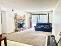 Spacious living room featuring a stone fireplace, plush carpeting, and sliding glass doors to a patio at 4281 S Salida Way # 5, Aurora, CO 80013