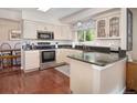 Well-lit kitchen featuring granite countertops, stainless steel appliances, and hardwood floors at 2935 Bow Line Pl, Longmont, CO 80503