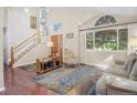 Bright living room with vaulted ceilings, hardwood floors, large windows and elegant staircase at 2935 Bow Line Pl, Longmont, CO 80503