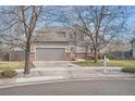 Two-story home with attached garage and driveway on a sunny day at 9306 W 13Th Pl, Lakewood, CO 80215