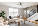 Cozy living room featuring hardwood floors, a white sofa, and black metal staircase at 11186 W Wisconsin Ave, Denver, CO 80232