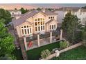 Aerial view of a backyard featuring a spacious deck, stairs, and lush landscaping around the property at 6047 Vacquero Cir, Castle Pines, CO 80108