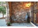 Cozy front porch featuring stone accents, seating, and a decorative light fixture adding character at 6047 Vacquero Cir, Castle Pines, CO 80108