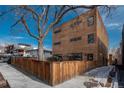 Modern home exterior with unique architectural design, warm wood siding, and a privacy fence at 1260 Newton St # 1, Denver, CO 80204