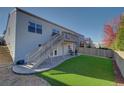 Backyard showing the home's exterior with a green lawn and a staircase leading to a deck on the upper level of the home at 19563 E Ithaca Pl, Aurora, CO 80013