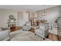 Cozy living room with hardwood floors, neutral paint, and stylish decor, open to dining area at 5819 W 82Nd Cir, Arvada, CO 80003