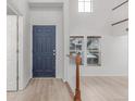 Welcoming foyer with a striking blue door, white walls, and natural light from a window at 7777 E 23Rd Ave # 1406, Denver, CO 80238