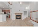 Sunlit living area features a fireplace, open staircase and view of the kitchen at 7777 E 23Rd Ave # 1406, Denver, CO 80238
