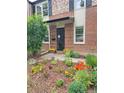 Inviting brick home with a meticulously maintained front yard adorned with vibrant flowerbeds and healthy plants at 1165 Krameria St, Denver, CO 80220
