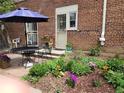 Brick patio includes a wrought-iron table set amidst a flower garden and brick pavers at 1165 Krameria St, Denver, CO 80220
