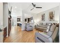 Spacious living room with hardwood floors, modern ceiling fan, and an open floor plan connecting to the kitchen at 7812 Inverness Blvd, Englewood, CO 80112