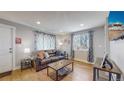 Living room featuring hardwood floors, a brown couch, and ample natural light at 2881 W 65Th Ave, Denver, CO 80221