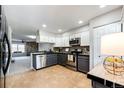 Bright kitchen boasts stainless steel appliances, granite counters, and tile floor at 8231 S Fillmore Way, Centennial, CO 80122
