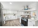 Bright kitchen featuring white cabinets, stainless steel appliances and a brick fireplace at 309 W Oak St, Lafayette, CO 80026