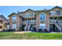 Condo building with stone accents, balconies, and a lush green lawn at 2846 W Centennial Dr # E, Littleton, CO 80123