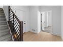 Bright entryway with wood floors, white walls, and a modern staircase with metal railings at 14245 Currant St, Broomfield, CO 80020