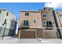 Modern home with garage and balcony showcasing sleek design with snow-covered ground at 14245 Currant St, Broomfield, CO 80020