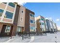A modern townhouse with large windows and accessibility ramp set in a snowy landscape at 14245 Currant St, Broomfield, CO 80020