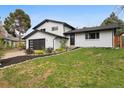 Charming two-story home with modern black garage door and nicely landscaped front yard at 7114 S Costilla St, Littleton, CO 80120