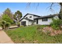 Beautifully renovated two-story home features landscaped front yard and modern black garage door at 7114 S Costilla St, Littleton, CO 80120