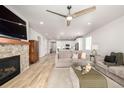 Inviting living room featuring a stone fireplace, open layout, and lots of natural light at 7202 S Valleyhead Ct, Aurora, CO 80016