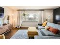 Bright living room featuring large window, contemporary decor, hardwood floors, and a cozy seating area at 1465 S Urban Way, Lakewood, CO 80228